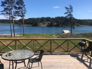 a table and chairs on a deck with a view of a lake at Kemping in Föglö