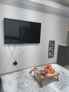 ein Wohnzimmer mit einem TV und einem Tisch mit Obst in der Unterkunft Farber Couple house in Naharija