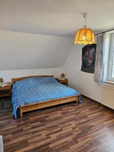 a bedroom with a bed with a blue comforter and a lamp at Carpe Diem in Grzybowo
