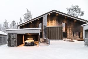 a car parked outside of a house in the snow at Villa Laponia in Äkäslompolo