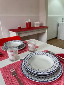 uma mesa com pratos e copos numa toalha de mesa vermelha em IL GIARDINO DI NONNO AGOSTINO em Castellammare di Stabia