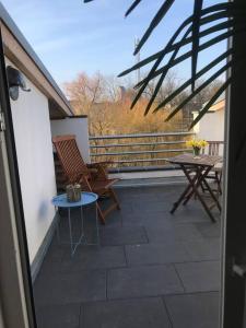 eine Terrasse mit einem Tisch und Stühlen auf dem Balkon in der Unterkunft Dachgeschosszimmer mit Terrasse in Wismar