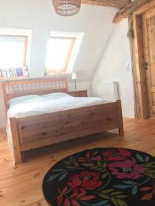 ein Schlafzimmer mit einem Holzbett und einem Teppich in der Unterkunft Dachgeschosszimmer mit Terrasse in Wismar