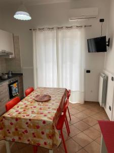 a kitchen with a table with red chairs and a table cloth at IL GIARDINO DI NONNO AGOSTINO in Castellammare di Stabia