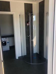 La salle de bains est pourvue d'une douche avec une porte en verre. dans l'établissement Kemping, à Föglö