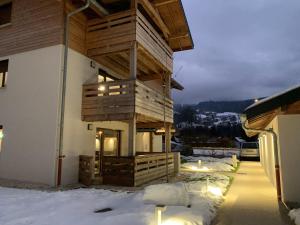 un edificio con una terraza con velas en la nieve en Apartment One, en Verchaix