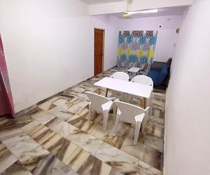 Habitación con mesa y sillas. en Simple Beseri Homestay, en Kangar