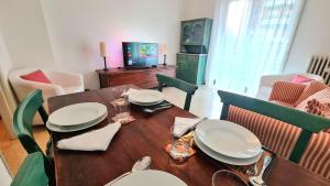 een eetkamer met een houten tafel met stoelen en een televisie bij Milano San Siro Stadio appartamento in Milaan