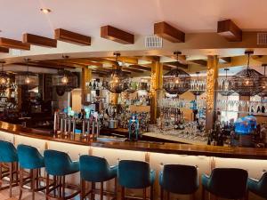 a bar with blue chairs in a room at Moycarn Lodge & Marina in Ballinasloe