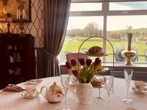 uma mesa com um vaso de flores e uma janela em Moycarn Lodge & Marina em Ballinasloe