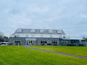 a large building with a grassy field in front of it at Moycarn Lodge & Marina in Ballinasloe
