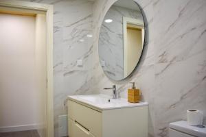 W łazience znajduje się umywalka i lustro. w obiekcie Apostolos Loft w mieście Évora