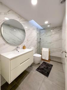 a bathroom with a sink and a toilet and a mirror at Apostolos Loft in Évora