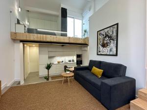 a living room with a blue couch and a loft at Apostolos Loft in Évora