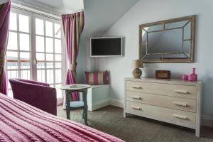 a bedroom with a bed and a dresser and a mirror at The Idle Rocks in Saint Mawes