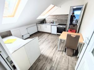 a kitchen with white cabinets and a person standing in the doorway at FMI110 Next to Airport in Rüsselsheim +18 photos