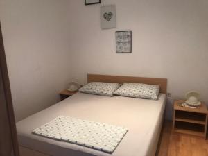 1 dormitorio con 1 cama con 2 almohadas en Apartman Lana, en Zablaće