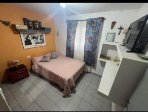 1 dormitorio pequeño con 1 cama y TV en Casa Villa de Merlo en Merlo