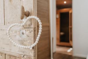 Una porta con un cuore fatto di perle sopra. di Privesauna Huisje 33 a Ermelo