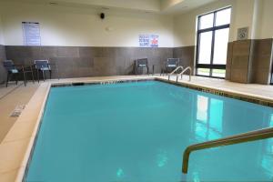 a large swimming pool with blue water in a building at Courtyard by Marriott Charlotte Waverly in Charlotte