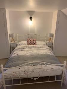 a bedroom with a white bed with two night stands at The Nest at Walnut Cottage in Burrowbridge