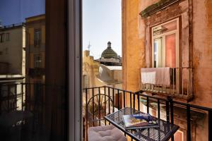 Palà Suites في نابولي: شرفة مع طاولة وإطلالة على مبنى