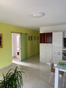 una cucina con pareti verdi e tavolo e sedie di Coral Dream ad Alghero
