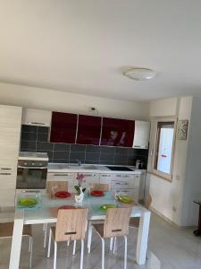 a kitchen with a white table and chairs in it at Coral Dream in Alghero