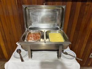 uma máquina de alimentos com duas bandejas de alimentos sobre uma mesa em Hotel Vila Rica em Maringá