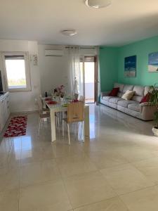 uma sala de estar com uma mesa e um sofá em Coral Dream em Alghero
