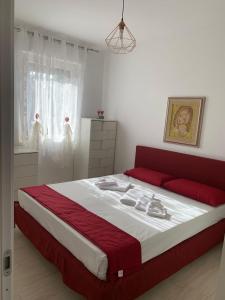 una camera da letto con un grande letto con lenzuola rosse e bianche di Coral Dream ad Alghero
