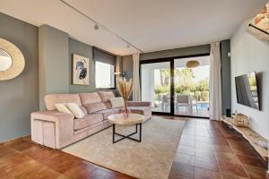 ein Wohnzimmer mit einem Sofa und einem Tisch in der Unterkunft Can Agua IBIZA - Fantastic Villa with pool & BBQ in San Jose de sa Talaia