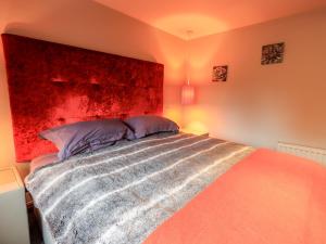 a bedroom with a large bed with a red headboard at The Curious Orange in Windermere