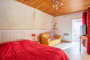 een slaapkamer met een rood bed en een gele stoel bij LaConciergerieJonzac, Résidence La Barberie in Saint-Martial-de-Vitaterne