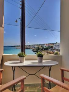 una mesa con 2 macetas en un balcón con ventana en Oinoni's Home - XANTHIPI apartment, en Souvala