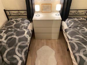 a bedroom with two beds and a dresser with two lamps at Ferienwohnung Irmchen in Altglobsow +18 photos