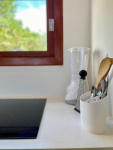 a kitchen counter with a cup with utensils on it at Casa Surya in São Miguel do Gostoso +6 photos