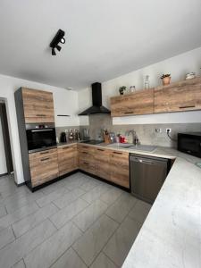 a kitchen with wooden cabinets and stainless steel appliances at Les tourterelles 