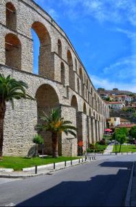 a brick building with arches and palm trees next to a street at Marinos in Kavala +8 photos