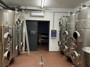 une chambre avec un tas de réservoirs en métal dans une brasserie dans l'établissement Johannesberg, à Zaječí