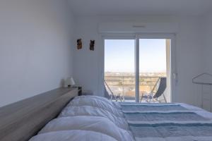 1 dormitorio con cama grande y ventana grande en La Désirade "Belle vue", en Jonzac