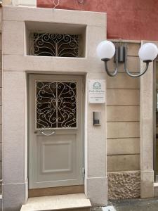 een deur naar een gebouw met een bord erop bij Perla Marina Luxury apartments in Margherita di Savoia