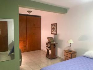 a bedroom with a bed and a table with books at Depto Centro in San Luis
