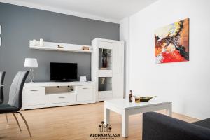 Biały salon z telewizorem i stołem w obiekcie Platea Cervantes, Centro Histórico by AlohaMálaga w Maladze