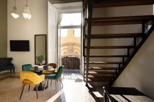 Palà Suites في نابولي: غرفة معيشة مع درج وطاولة وكراسي