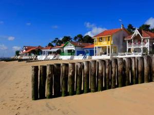 een rij huizen op het strand naast een pier bij La maisonnette de Suzette in Lanton