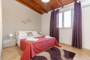 een slaapkamer met een bed met een rode deken bij A casa di Maria in Catania