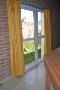 an open window with yellow curtains in a room at Coqueto departamento, Jardines del Rey in Neuquén