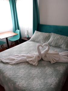 Dos espantapájaros para parecer corazones sentados en una cama en HOSTAL SUITE 1 Oriente 1075, Viña del Mar en Viña del Mar