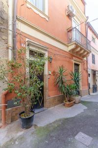 een gebouw met twee potplanten ervoor bij A casa di Maria 2 in Catania